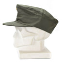 Original German Army olive green field cap with curved visor displayed on white mannequin head profile view