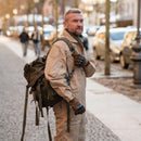 Man wearing Original Austria military tactical backpack 25L with detachable top cover in olive green on city street