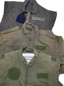 Three different colored military-style flight suit coveralls with zip fronts and velcro patches displayed flat