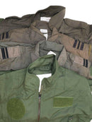 Stack of original Dutch army aramid carbon fiber flight suit coveralls in various military green shades.