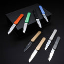 Eight Fox Knives pocket knives with various colored handles and stainless steel blades displayed on a black surface.