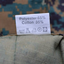 Close-up of care label showing fabric composition 65% polyester 35% cotton on digital savana camo pants