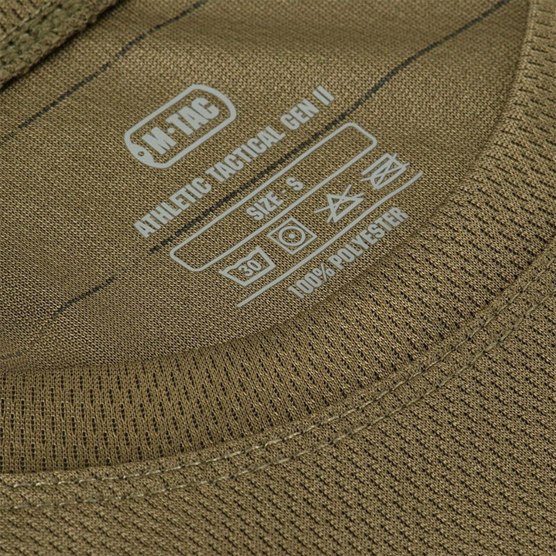 Close-up of olive M-TAC Military Tactical T-Shirt label showing size and fabric care details on breathable polyester fabric