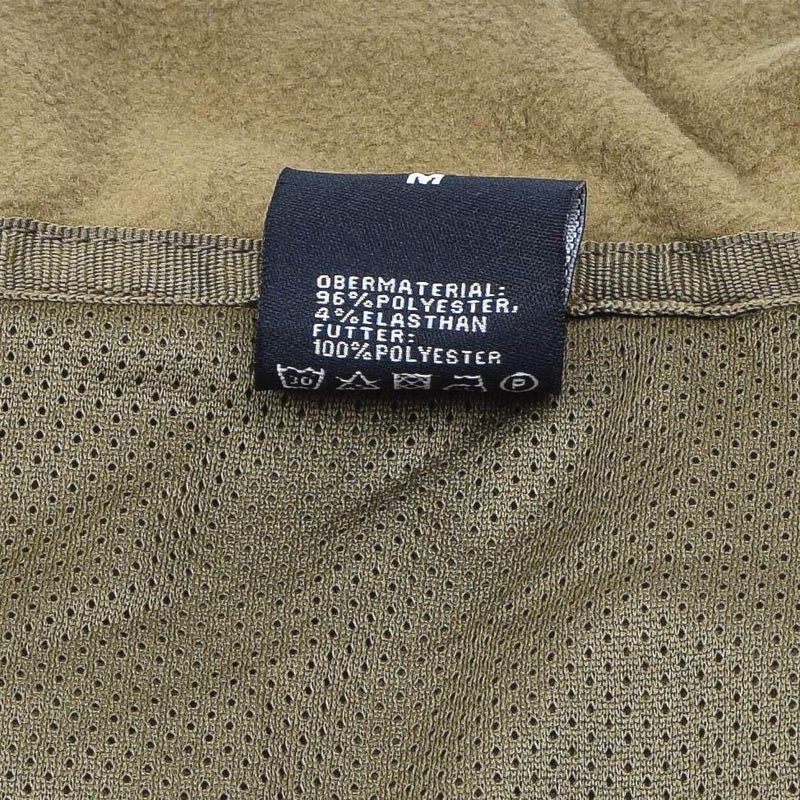 Close-up of MIL-TEC SCU14 jacket dark coyote mesh lining and fabric composition label with care instructions.