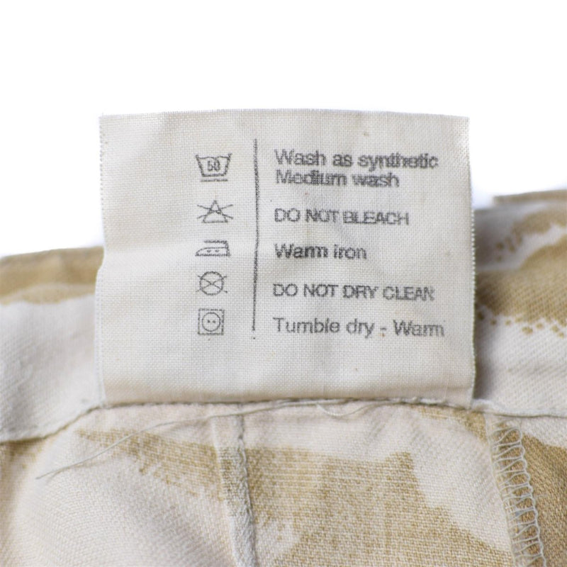 Care label on British army desert pants showing washing instructions including medium wash and warm iron only