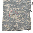Torn area on digital camouflage U.S. Army reversible tarp ground cover blanket fabric close-up.