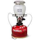 Primus EasyLight Duo gas lantern with white glass globe and red gas canister for camping and hiking illumination.