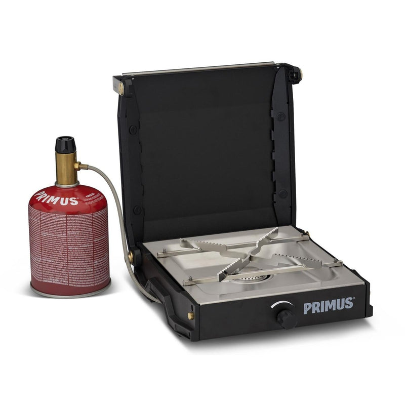 Primus Moja compact camping stove with gas canister, enameled pot supports, and windscreen for outdoor cooking.