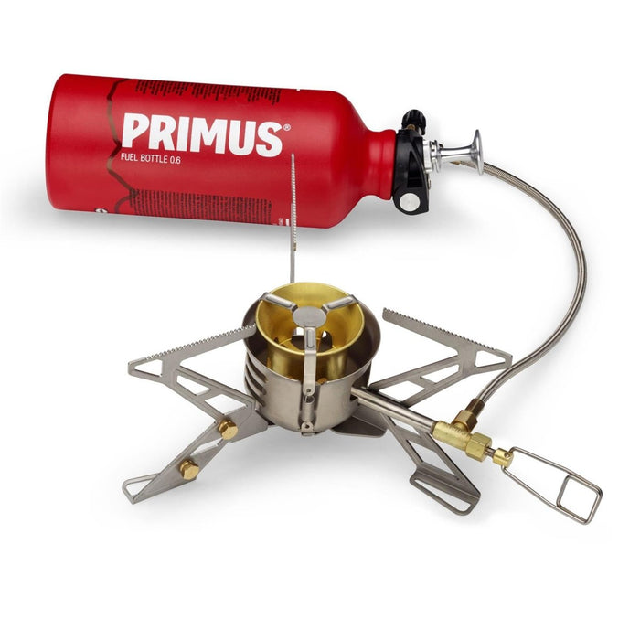 Primus OmniFuel II flerbränslecampingkamin med röd bränsleflaska, stöd i rostfritt stål och bränsleslang för matlagning utomhus.