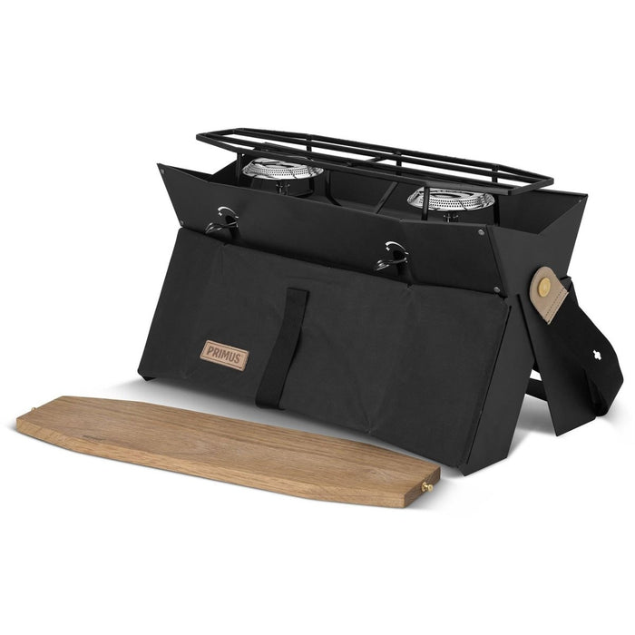 Kompakt Primus Onja campingspis med dubbla brännare med vikbar design och vindruta i trä för matlagning utomhus.