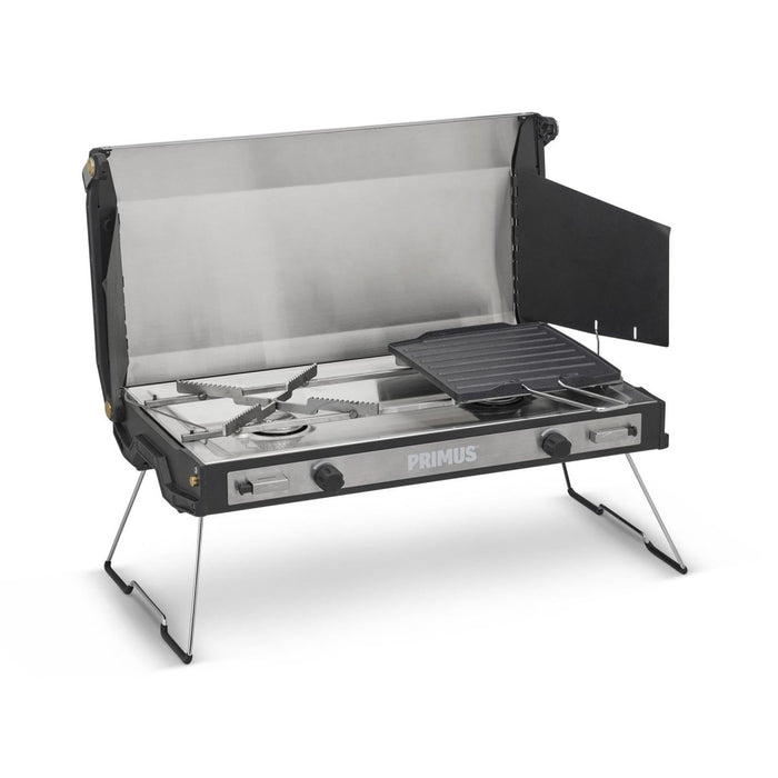 Primus Tupike dubbel gasbrännare utomhuscampingspis med vikbara ben och non-stick grillplatta för mångsidig matlagning.
