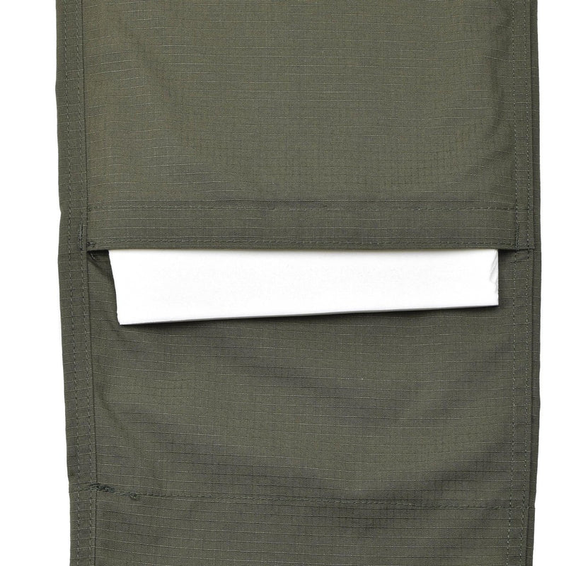 Close-up of olive ripstop fabric cargo pocket on TACGEAR military reinforced tactical pants with white item inside pocket